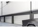 Row of three garages featuring white garage doors, grey pillars, and modern building facade at 223 16Th Nw St # 2, Atlanta, GA 30363