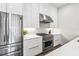 Close-up of stainless steel refrigerator and gas range with white cabinetry in a modern kitchen at 223 16Th Nw St # 2, Atlanta, GA 30363