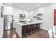 The modern kitchen features sleek white cabinets, stainless steel appliances, and a large island with bar seating at 223 16Th Nw St # 2, Atlanta, GA 30363