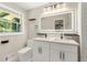 Bright bathroom featuring double vanity, backlit mirror, and contemporary fixtures at 2682 Miriam Ln, Decatur, GA 30032