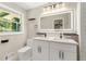 Bright bathroom boasts a double sink vanity, contemporary fixtures, and a large, illuminated mirror at 2682 Miriam Ln, Decatur, GA 30032