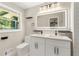 Bright bathroom with dual sinks, modern fixtures, and a backlit mirror at 2682 Miriam Ln, Decatur, GA 30032