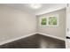 Bedroom with hardwood floors, neutral walls, and natural light from the large window at 2682 Miriam Ln, Decatur, GA 30032