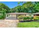 Charming ranch-style home with lush front yard landscaping and a covered carport on a sunny day at 2682 Miriam Ln, Decatur, GA 30032