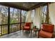 Relaxing screened porch featuring comfortable chairs, slate flooring, and views of the wooded backyard at 2871 Parkridge Ne Dr, Brookhaven, GA 30319