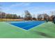 Well-maintained tennis court with a vibrant blue surface, surrounded by lush greenery, perfect for recreational play at 2871 Parkridge Ne Dr, Brookhaven, GA 30319