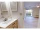 Bathroom featuring a sink, updated vanity, mirror, and view into adjacent living space with balcony at 300 Johnson Ferry Ne Rd # B103, Atlanta, GA 30328