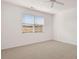 Bright, carpeted bedroom featuring a ceiling fan and a large window with blinds at 617 Kimberwick Dr, Locust Grove, GA 30248