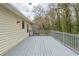 Side view of a light grey deck with painted wood planks and railings, and view of backyard at 1492 Cobb Branch Dr, Decatur, GA 30032