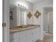 Bathroom featuring double vanity with a decorative mirror and a shower in the background at 70 Nw Willow Bend Dr, Cartersville, GA 30121