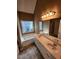 Bathroom featuring dual vanity sinks, a large soaking tub and a big window at 959 Gettysburg Way, Locust Grove, GA 30248