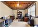 Basement office space with exposed beams, built-in shelving, and a large work desk at 118 Fairway Overlook Dr, Acworth, GA 30101