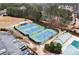 Aerial view of well-maintained tennis courts in a residential community with lush greenery and a clubhouse at 118 Fairway Overlook Dr, Acworth, GA 30101