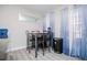 Dining area featuring a black dining table and chairs next to big windows with blue curtains at 185 Whetstone Way, Villa Rica, GA 30180