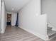 Hallway with gray wood floors, gray walls, leading to a doorway and stairs at 185 Whetstone Way, Villa Rica, GA 30180