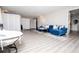 Living room featuring gray wood floors, blue sofa, papasan chair, and privacy screens at 185 Whetstone Way, Villa Rica, GA 30180