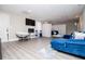 Living room featuring gray wood floors, blue sofa, papasan chair, and tv at 185 Whetstone Way, Villa Rica, GA 30180