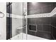 The black tiled shower and tub combination is complete with a sleek glass door and tiled soap niche at 2760 Swansea Ct, College Park, GA 30349