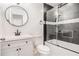 This modern bathroom boasts a round mirror and a shower and tub combination with sleek glass doors at 2760 Swansea Ct, College Park, GA 30349