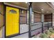 Front porch with a bright yellow door, black trim, and colorful flowers adding to the home's curb appeal at 2760 Swansea Ct, College Park, GA 30349