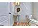 Cozy powder room with pedestal sink, toilet, and decorative lighting at 2790 Laurel Valley Trl, Buford, GA 30519