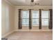 Carpeted bedroom with windows and black and white patterned curtains at 2790 Laurel Valley Trl, Buford, GA 30519