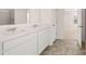 Bathroom with double sinks, white cabinets, and a view into the Primary bedroom at 629 Kimberwick Dr, Locust Grove, GA 30248