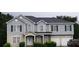 Two-story home featuring gray siding, black shutters, and a two-car garage, set against a lush green backdrop at 3551 Northgate Cv, Ellenwood, GA 30294
