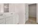 Bathroom featuring double sinks, white cabinets and a door leading to a walk in closet at 633 Kimberwick Dr, Locust Grove, GA 30248