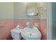 Bathroom featuring pink tiling, a toilet, and a sink with a mirror above it at 1690 Carter Rd, Decatur, GA 30032