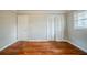 Bedroom showcasing hardwood floors and white closet doors at 1690 Carter Rd, Decatur, GA 30032