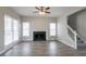 Open-concept living room with hardwood floors, large windows, and a modern fireplace at 3040 Washington Rd, Atlanta, GA 30344