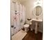 Bathroom featuring a decorative shower curtain, pedestal sink, and round mirror at 3601 Orchard Cir, Decatur, GA 30032