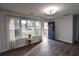 Bright living room with large windows, sheer curtains, stylish wood floors, and a welcoming navy blue front door at 3601 Orchard Cir, Decatur, GA 30032