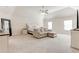 Spacious main bedroom featuring neutral walls and carpet, along with a comfortable seating area beneath a ceiling fan at 6188 Riddle Ct, Douglasville, GA 30134