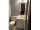 Bathroom with white vanity, toilet, and framed mirror reflecting a view into another room at 3315 Canterbury Trl, Rex, GA 30273