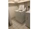 Bright laundry room with white washer and dryer, tiled floor and wire shelving at 3315 Canterbury Trl, Rex, GA 30273