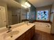 Bathroom featuring a soaking tub, decorative window, a double sink vanity, and separate shower at 3650 Burnt Hickory Dr, Dacula, GA 30019