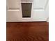 Close-up view of a white pet door installed in an interior door, with hardwood floors visible at 3650 Burnt Hickory Dr, Dacula, GA 30019