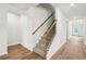An interior view of a carpeted staircase with wood and wrought iron balusters and wood-look flooring at 3954 Brushy St, Powder Springs, GA 30127