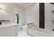 Bathroom features modern tub, black and white marble accent wall, and sink and vanity with marble countertop at 10745 Shallowford Rd, Roswell, GA 30075