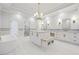 Large bathroom with marble floors, tub, shower, dual vanities, white cabinets, and stylish lighting at 10745 Shallowford Rd, Roswell, GA 30075