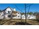 Expansive white home featuring a charming covered balcony and lush surroundings at 10745 Shallowford Rd, Roswell, GA 30075