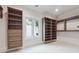 Custom walk-in closet featuring built-in shelving, drawers, and a window at 10745 Shallowford Rd, Roswell, GA 30075