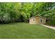Secluded backyard featuring a lush lawn, mature trees, and a shed at 1303 N Druid Hills Ne Rd, Brookhaven, GA 30319