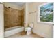 Bright bathroom with bathtub/shower combo and earthy tile surround at 1303 N Druid Hills Ne Rd, Brookhaven, GA 30319