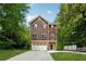 Charming two-story home with shingle and brick facade, complemented by a well-manicured lawn and ample driveway at 1303 N Druid Hills Ne Rd, Brookhaven, GA 30319