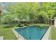 In-ground pool with two lounge chairs surrounded by lush green foliage at 1303 N Druid Hills Ne Rd, Brookhaven, GA 30319