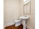 Powder room with pedestal sink, toilet, and decorative mirror at 1303 N Druid Hills Ne Rd, Brookhaven, GA 30319