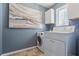 Bright laundry room with art, washer, dryer, and ample cabinet space at 1310 Dillon Rd, Austell, GA 30168